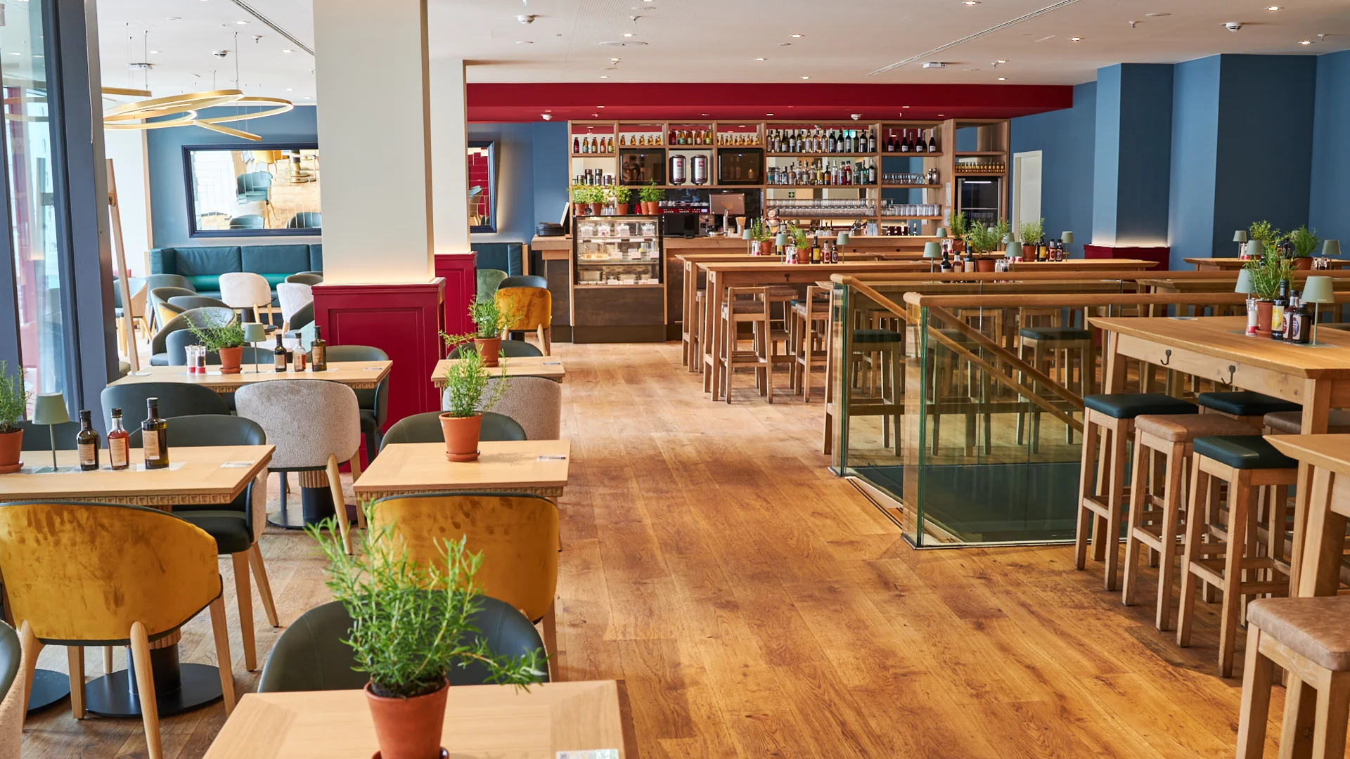 Innenaufnahme vom VAPIANO Hamburg Gänsemarkt mit Tischen, Stühlen und der Bar im Hintergrund.