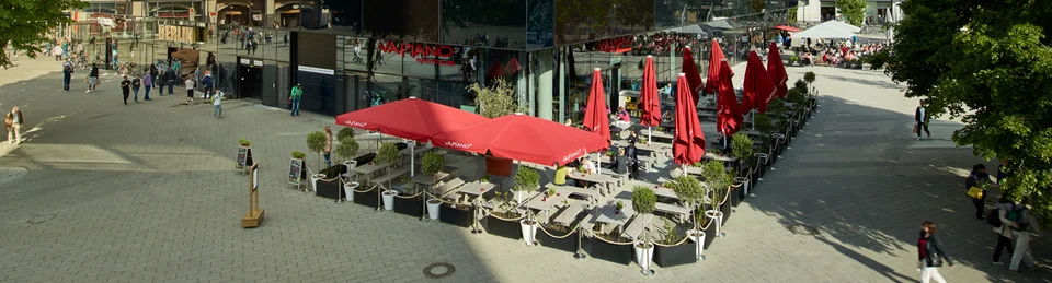 Ein großes Gebäude in der Fußgängerzone mit dem VAPIANO Berlin Alexanderplatz im Erdgeschoss.