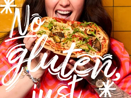 Eine Frau hält eine Pinsa und freut sich. 