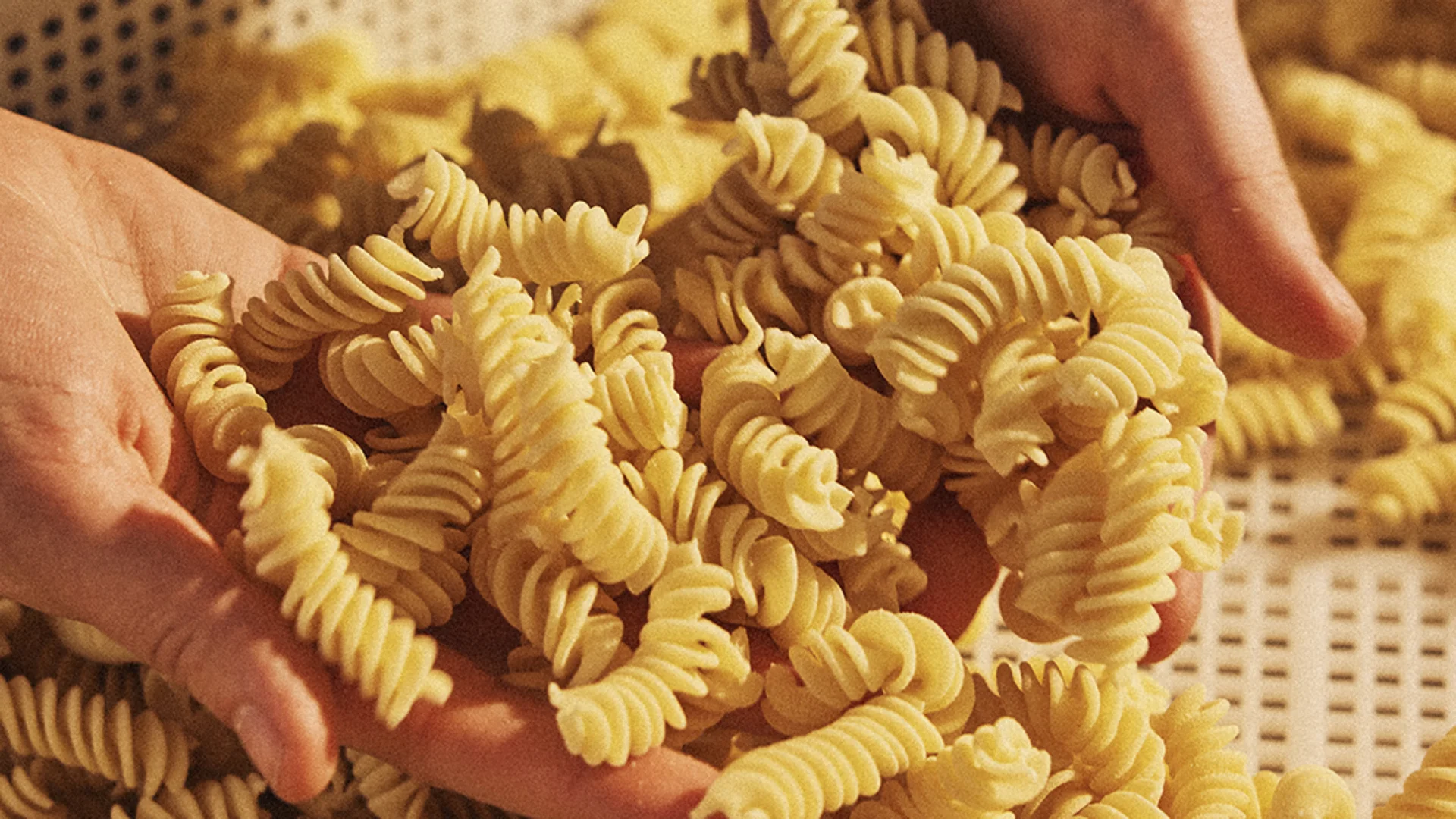Vapianisti hält hausgemachte Fusilli in den Händen.