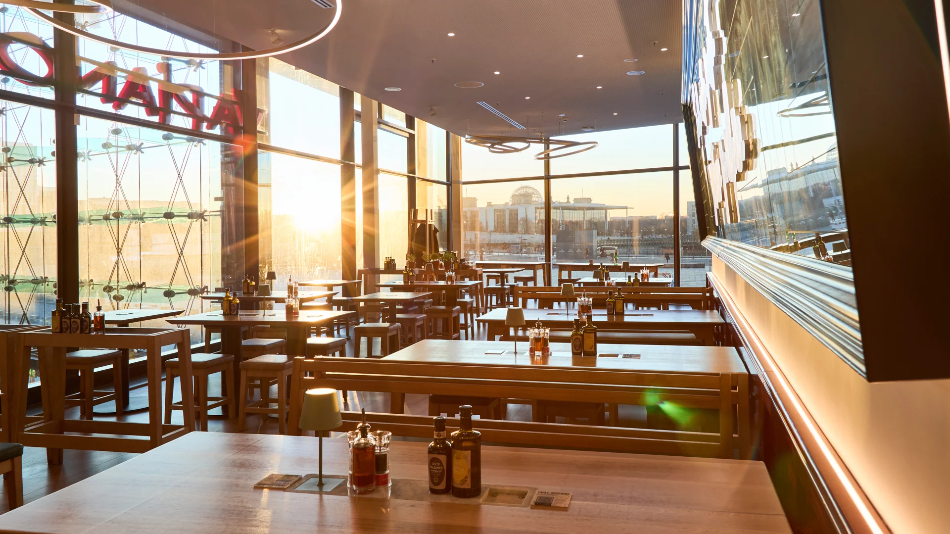 Innenaufnahme vom VAPIANO Berlin Europaplatz mit Blick auf die untergehende Sonne. 
