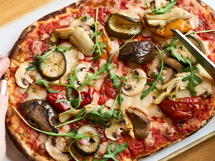 Pinsa mit Gemüse und Rucola wird serviert