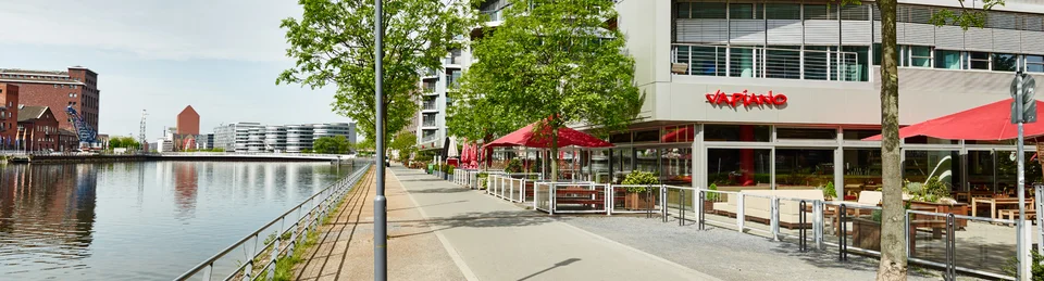 Außenansicht vom VAPIANO Duisburg nahe Fußgängerweg und Kanal. 