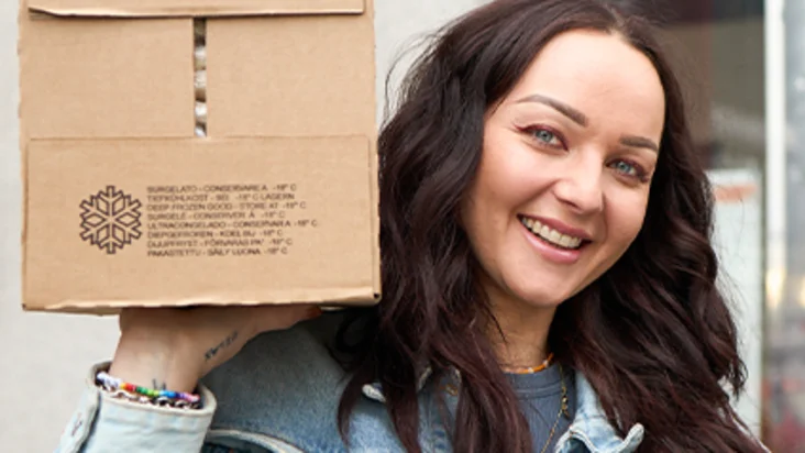 Eine Frau trägt einen Karton von "Dr. Schär"