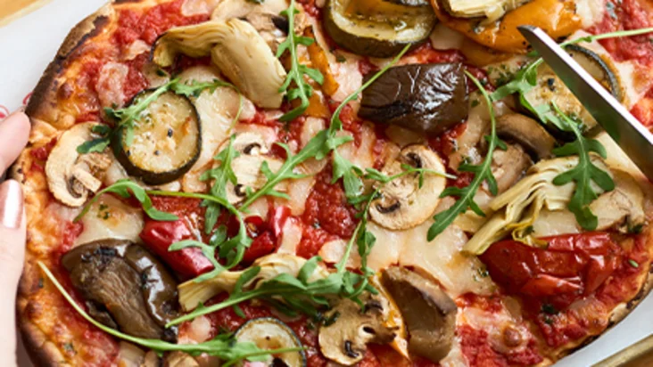 Pinsa mit Gemüse und Rucola wird serviert